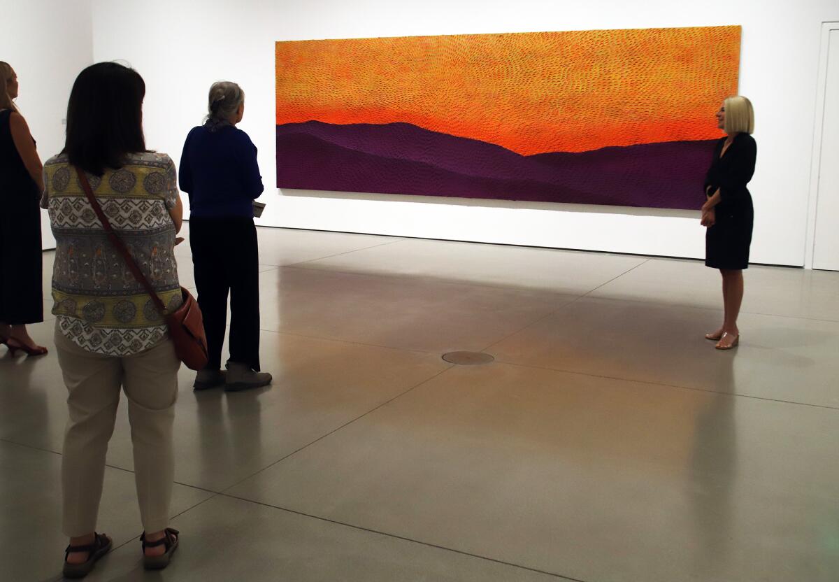 Heidi Zuckerman, the CEO and director of OCMA, right, discusses the work of artist Jennifer Guidi.