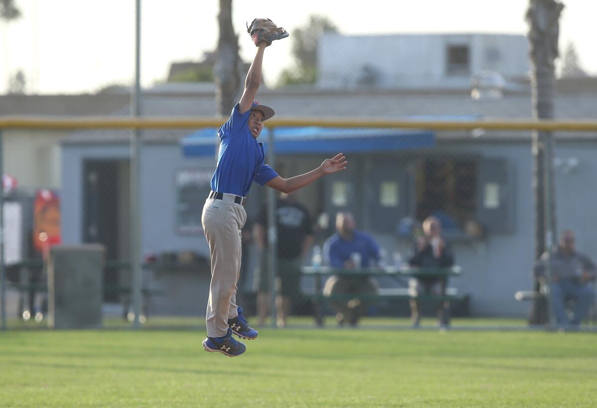 Huntington West Little League's Ryo DeGuzman leaps to catch ball for an out during the District 62 Tournament of Champions Major Division quarterfinal game against Costa Mesa National on Tuesday at Ocean View Little League.