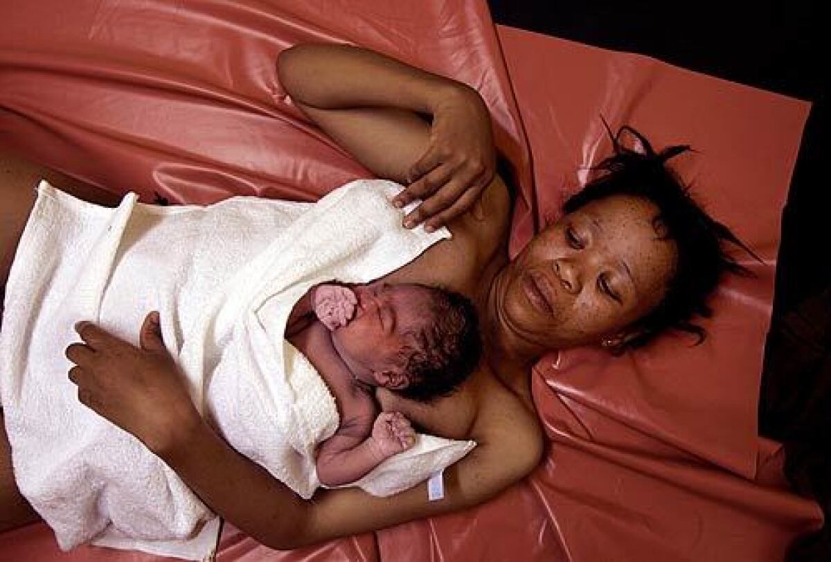 Mother and daughter: Lizketseng Lesaoana, 25, half an hour after delivering a baby girl at Queen Elizabeth II Hospital in Maseru, Lesotho. They lie on a plastic sheet that is cleaned with a damp cloth between births. Video