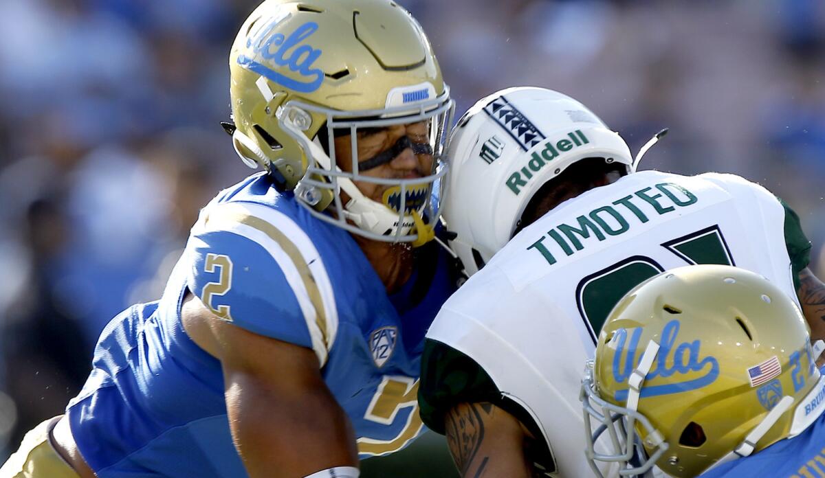 Hawaii wide receiver Kalakaua Timoteo drops the ball as he gets leveled by UCLA linebacker Josh Woods (2) and defensive back Mossi Johnson earlier this season. Woods was penalized and ejected for targeting.