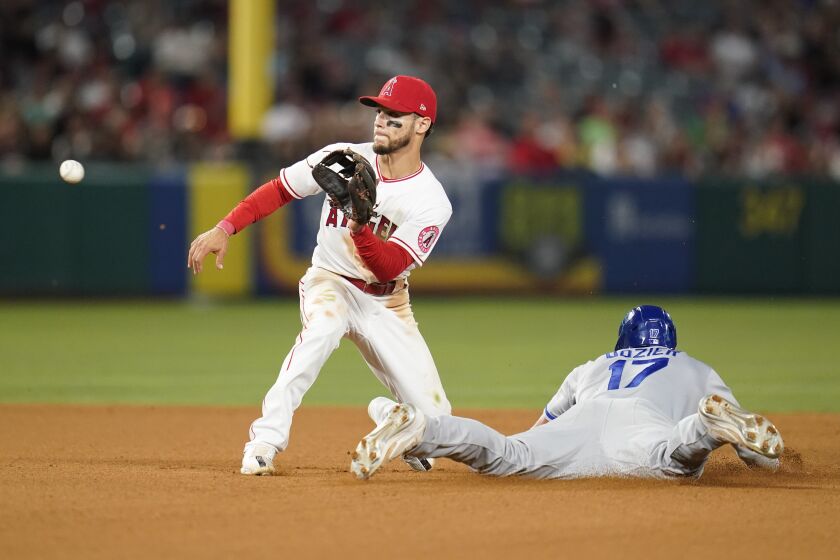 Kansas City Royals' Hunter Dozier (17) steals second ahead of a throw to Los Angeles Angels shortstop Andrew Velazquez (4) during the seventh inning of a baseball game in Anaheim, Calif., Monday, June 20, 2022. (AP Photo/Ashley Landis)