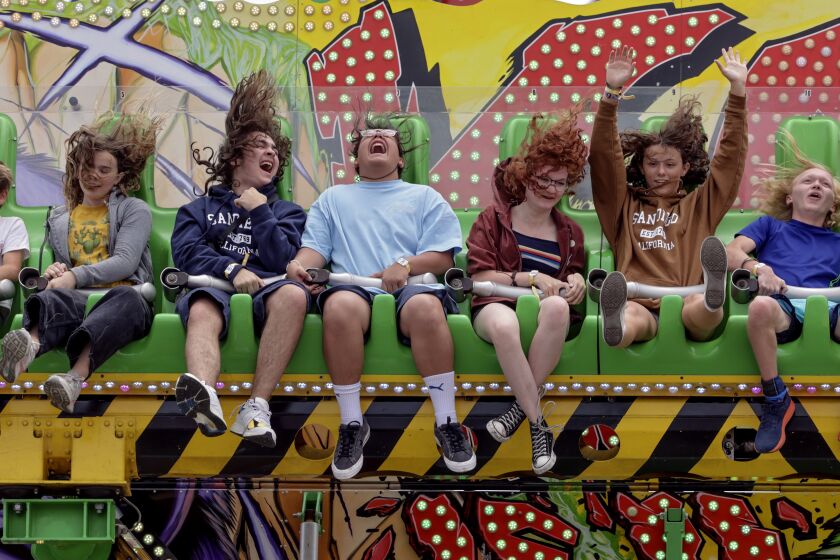 DEL MAR, CA - JUNE 07, 2023: Miguel Sanchez, 16, center, laughs as he and fellow teens from a high school youth church group from Scottsdale, Arizona ride the Konga on opening day of the San Diego County Fair in Del Mar on Wednesday, June 7, 2023. (Hayne Palmour IV / For The San Diego Union-Tribune)