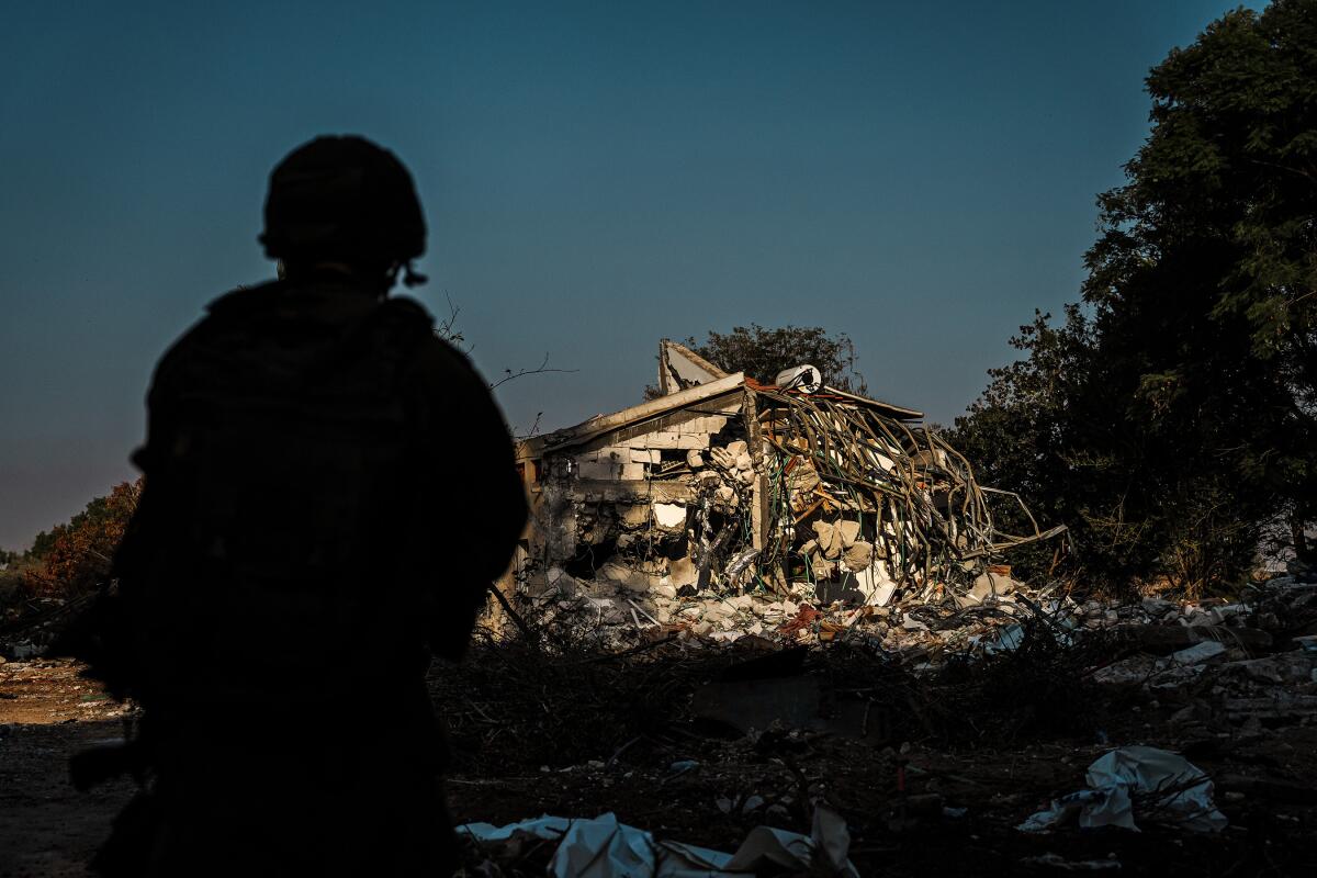 A silhouette of a soldier in front of a building in ruins. 