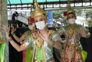 Thai classical dancers wearing face masks to help protect themselves from the coronavirus perform at the Erawan Shrine in Bangkok, Thailand, Monday, Feb. 7, 2022. (AP Photo/Sakchai Lalit)