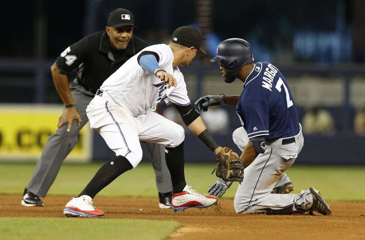 Padres center fielder Manuel Margot slides into second base with a double as Miami Marlins shortstop Miguel Rojas applies a late tag.