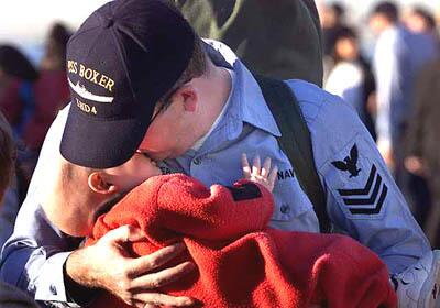 Petty Officer Brian Meyer, USN, gives a goodbye hug and kiss to his baby son Brody, 10 months.