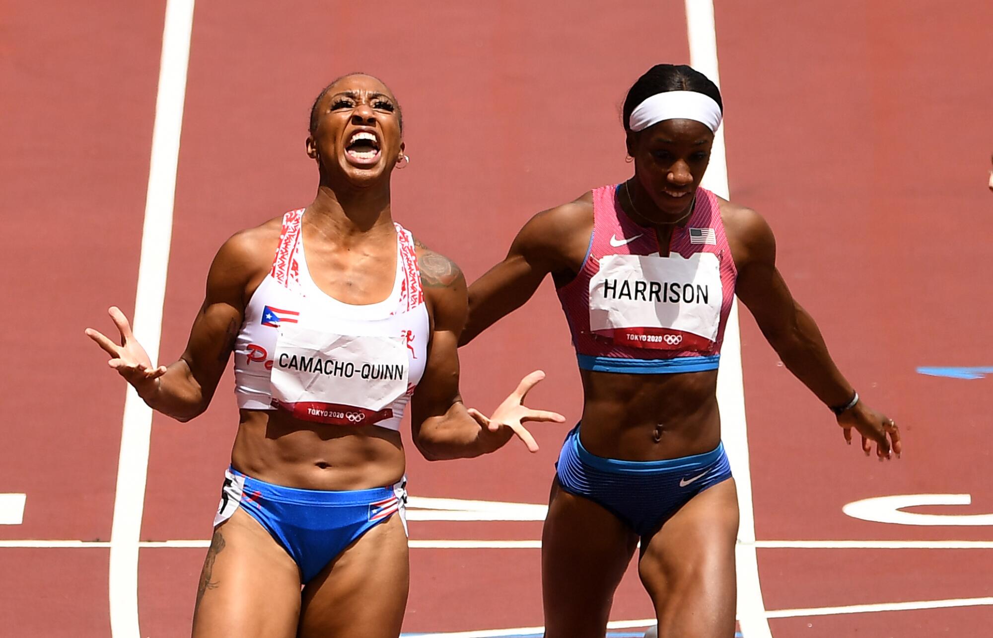 A female runner spreads her fingers and, holding her head back, shouts up at the sky.