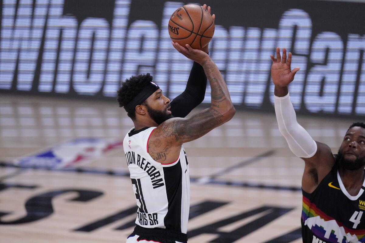 The Clippers' Marcus Morris shoots as the Denver Nuggets' Paul Millsap defends Sept. 13, 2020.