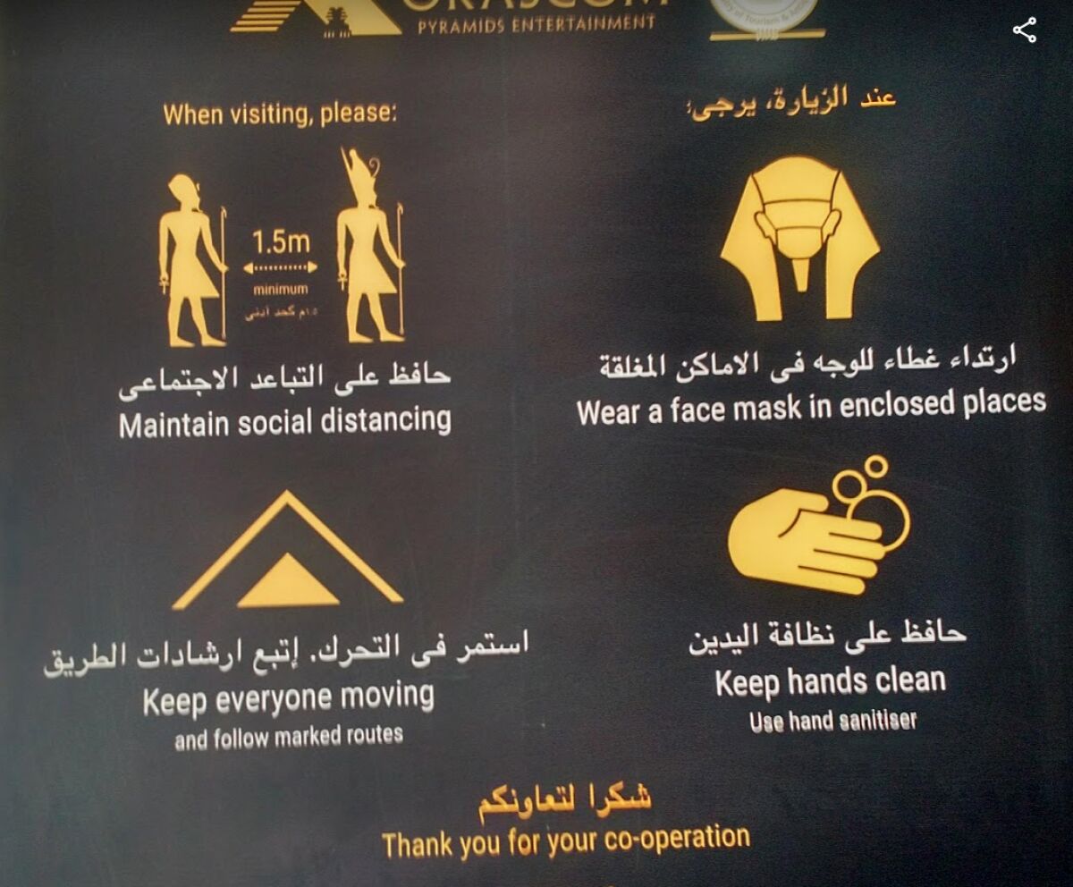 Egyptian signs for tourists give pandemic health instructions.