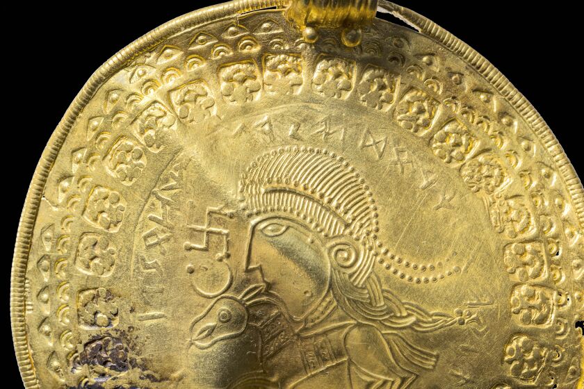 La inscripción "es el hombre de Odín" se ve en semicículo sobre una figura en un bracteato dorado desenterrado en Vindelev, Dinamarca, a finales de 2020. Los científicos han identificado la mención más antigua conocida al dios nórdico Odín en un disco de oro encontrado en el oeste de Dinamarca. (Arnold Mikkelsen, Museo Nacional de Dinamarca via AP)