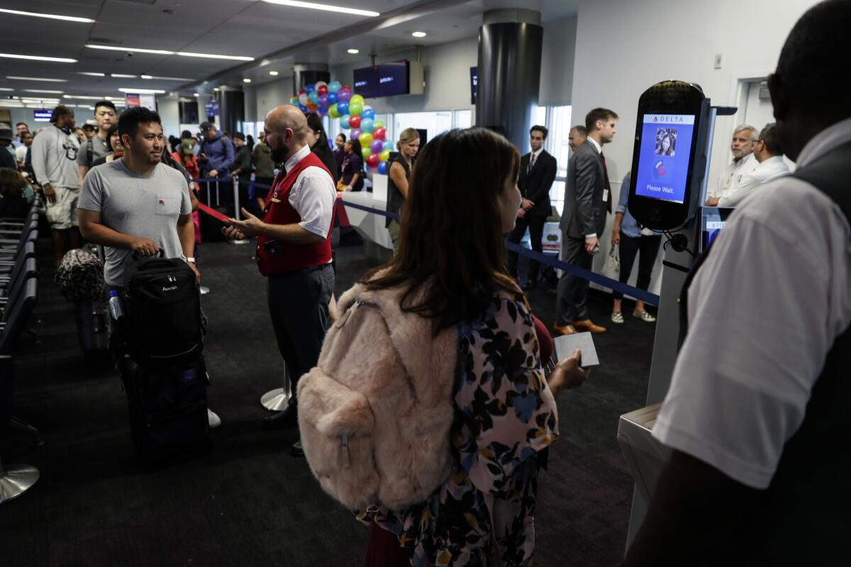 Airline passengers wait to go through an airport security checkpoint.