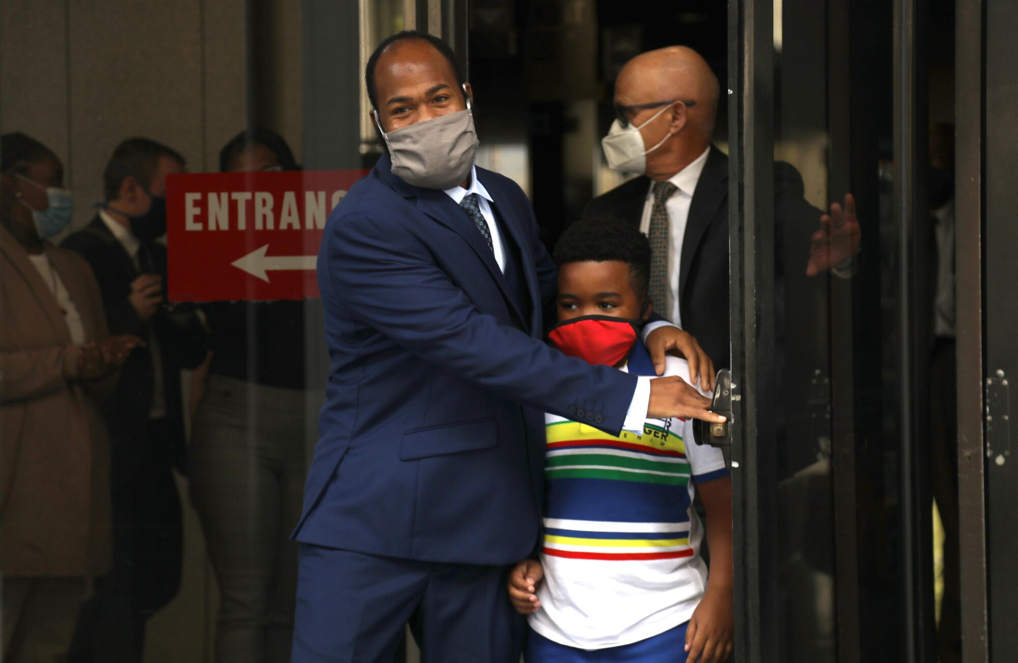 Derrick Harris walks out of a court building with his son Derrick Jr., 9.