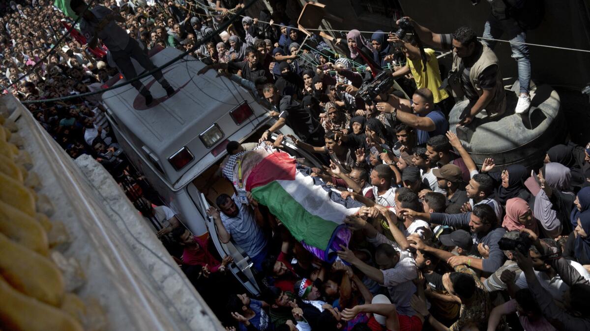Palestinian mourners carry the body of Razan Najjar, 21, during her funeral in Gaza on Saturday.