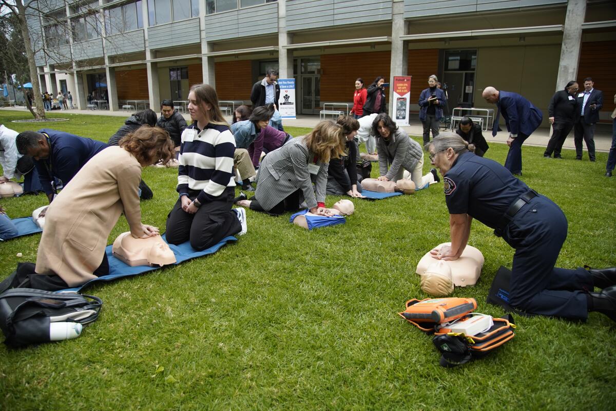 Right, Maureen O'Connor with project heart beat teaches CPR to a group at UC San Diego in La Jolla on Monday, Feb. 26, 2024.