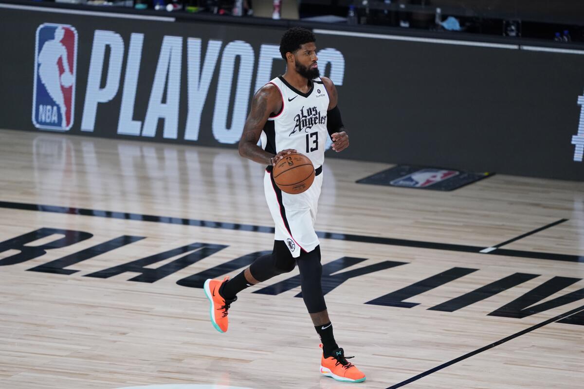 Clippers forward Paul George brings the ball up court against the Mavericks during Game 5 on Tuesday.