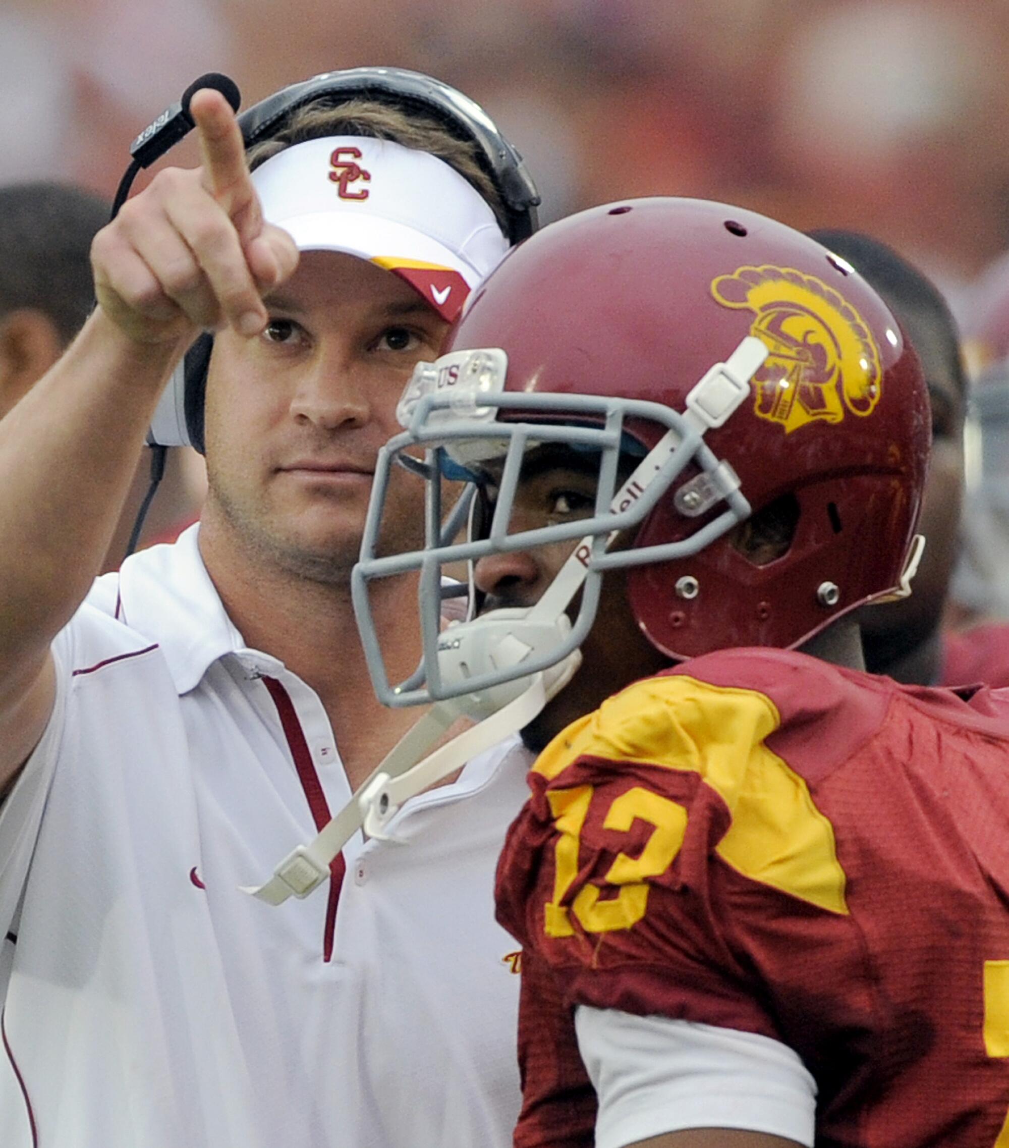 USC wide receiver Robert Woods watches a replay of his second touchdown with coach Lane Kiffin.
