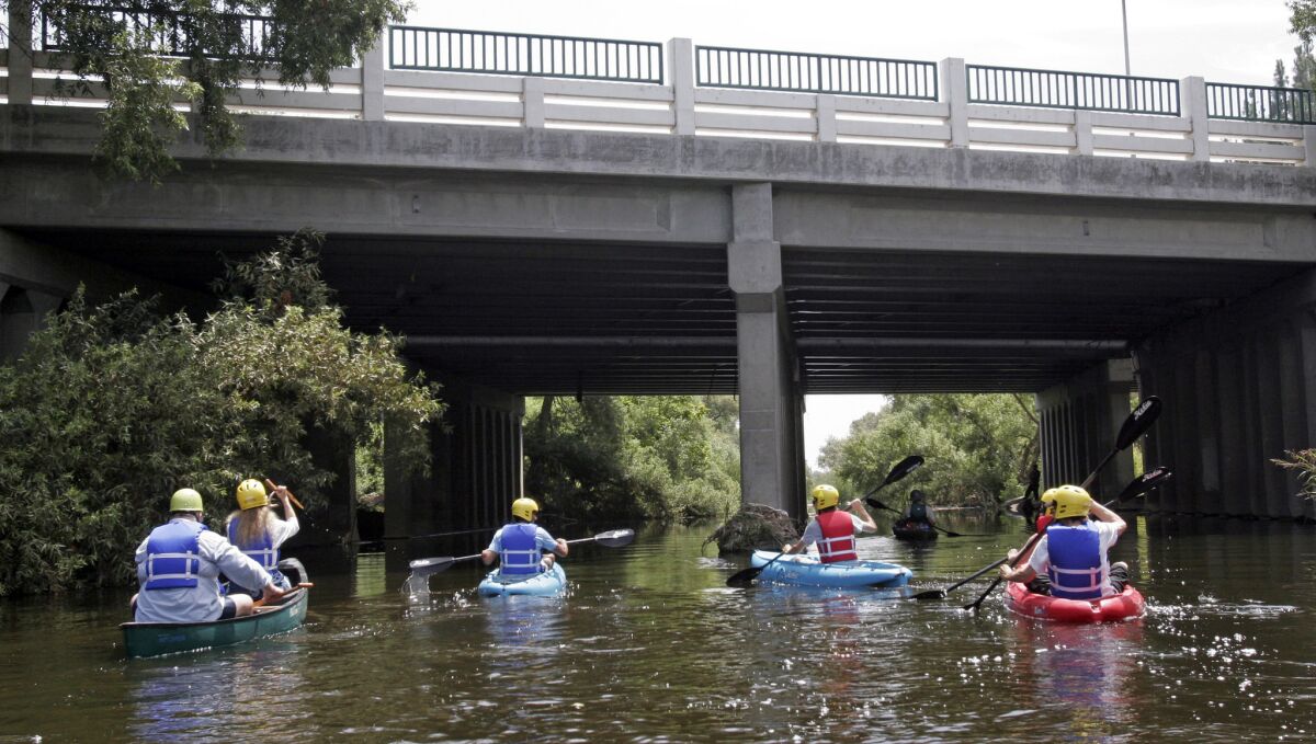 Kayakers paddle down the Los Angeles River in the Sepulveda Dam recreation area in Van Nuys.