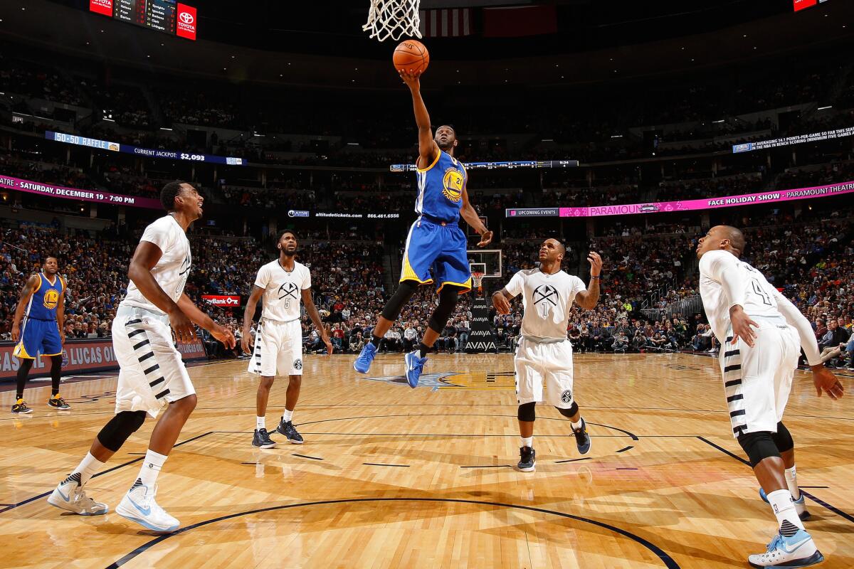 Warriors guard Ian Clark lays up a shot as four Denver defenders watch. The Warriors defeated the Nuggets, 118-105, to start the season 15-0.