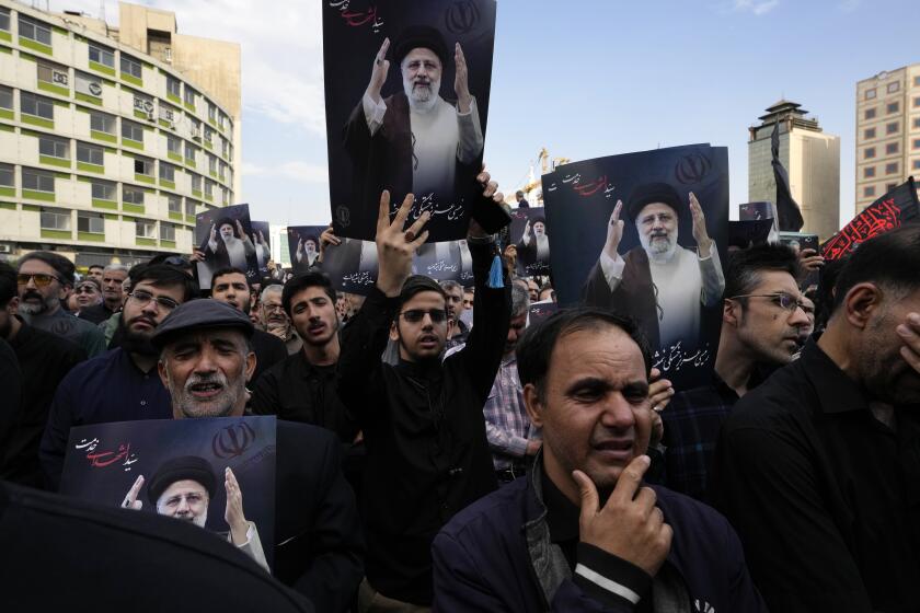 Varias personas sostienen imágenes del presidente iraní Ebrahim Raisi durante una ceremonia en su honor en Teherán, Irán, el lunes 20 de mayo de 2024. (AP Foto/Vahid Salemi)