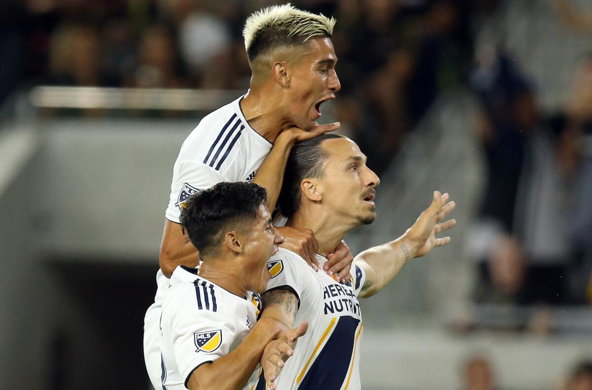 Galaxy forward Zlatan Ibrahimovic (center) celebrates with teammates Favio Alvarez (top) and Uriel Antuna after scoring his second goal against LAFC on Sunday.