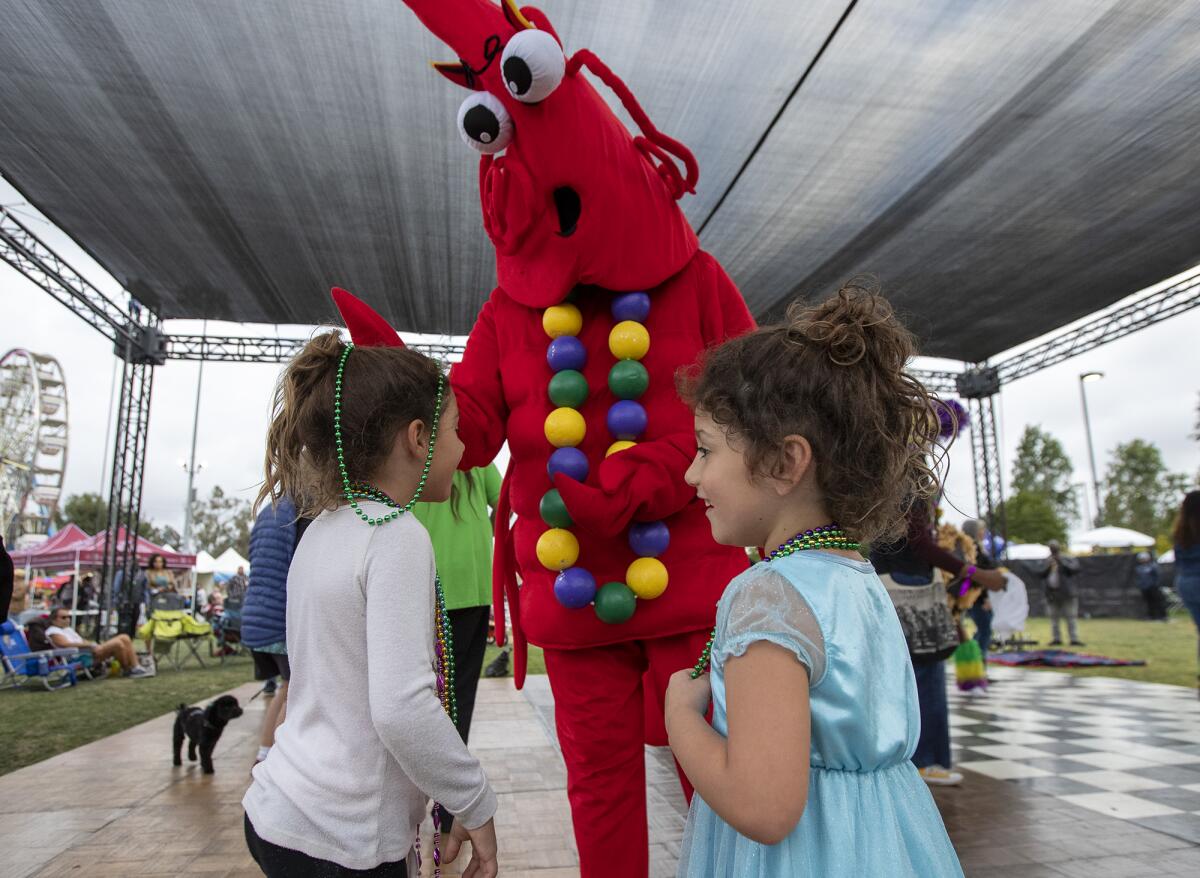 Samantha and Christine Yarina get beads from a giant crawfish mascot during the Crawfish Festival.