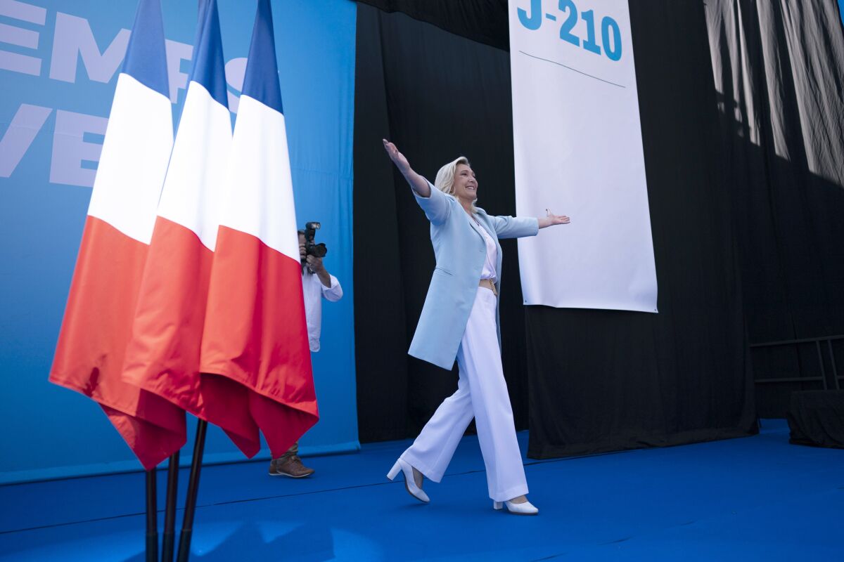 FILE- Marine Le Pen walks on stage, at a National Rally event in Frejus, Sunday, Sept. 12, 2021. French nationalist Marine Le Pen has softened her rhetoric and her image as she tries to unseat centrist President Emmanuel Macron in the upcoming election, taking place in two rounds on April 10 and 24. She is honing in on the pocketbook issues that voters care about most. But the woman who has been known for her fierce anti-immigration stance is also facing a challenge from TV pundit Eric Zemmour, a more provocative candidate who styles himself after Donald Trump and embraces racist conspiracies. Their rivalry illustrates France’s tilt toward the hard right. (AP Photo/Daniel Cole, File)