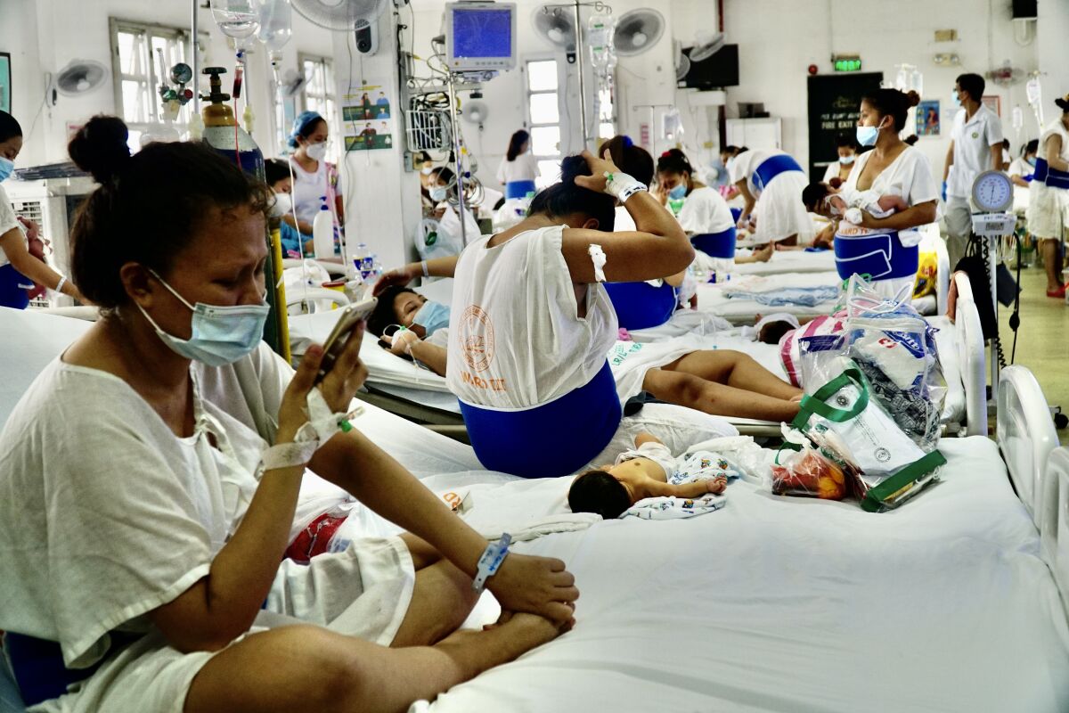 Women on hospital beds in a crowded maternity ward