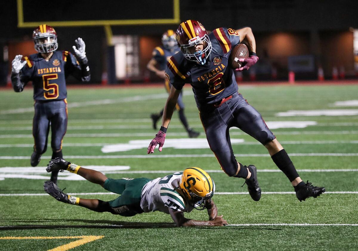 Estancia's Trevor Thomas (8) is tripped up just short of the end zone during an Orange Coast League football opener.