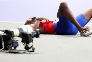 American Noah Lyles lays on the track after winning the bronze medal during the men's 200-meter final Thursday in Paris.