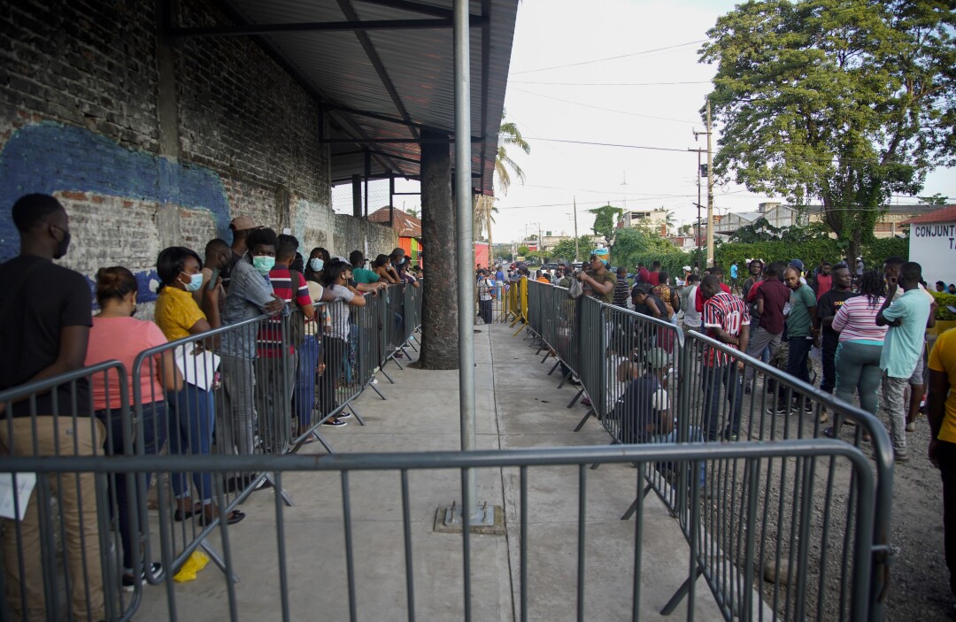 Asylum seekers wait outside a Tapachula office responsible for identifying refugees