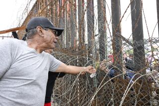 Protester Stan Rodriguez reaches across the border fence between at the U.S.-Mexico border fence at Friendship Park May, 21, 2023 in San Diego, Calif. The protesters object to a proposed 30 foot high double border wall that will end cross border interaction at the park (Photo by Denis Poroy)