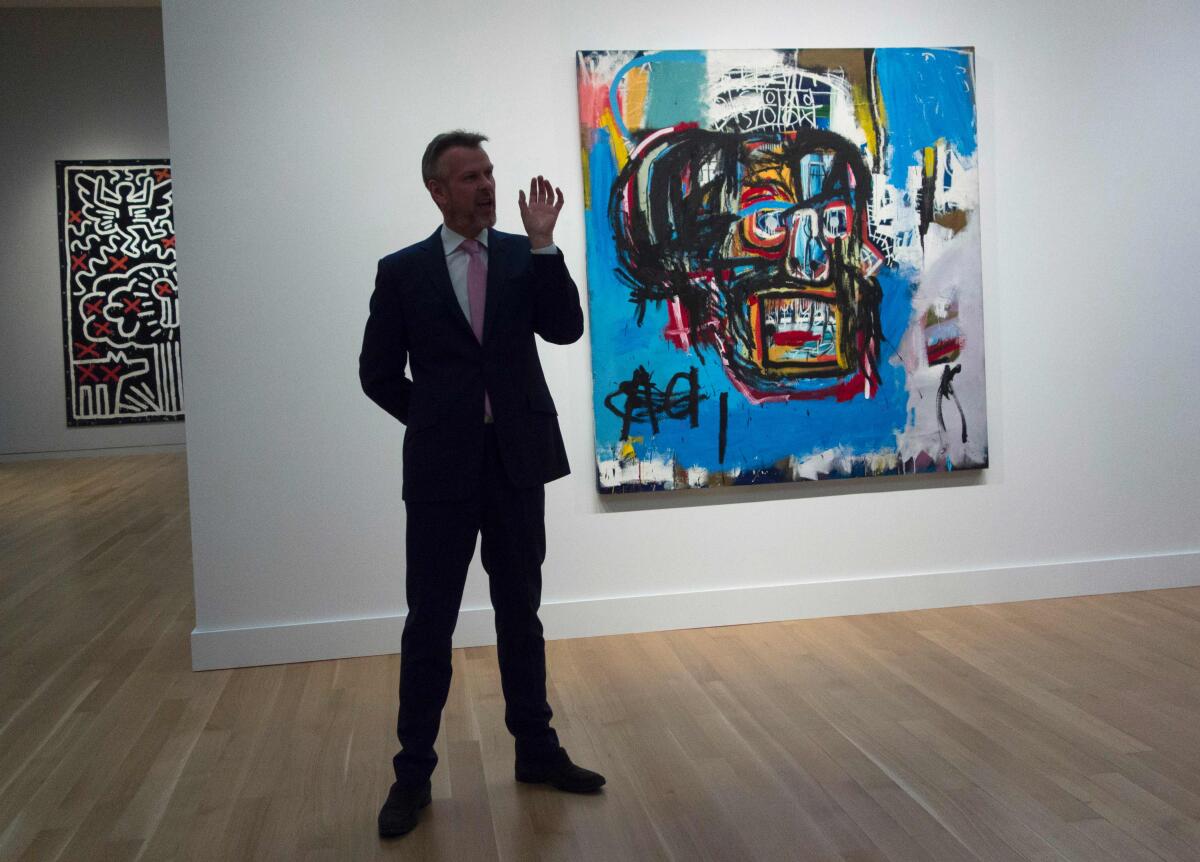 A Sotheby's official discusses "Untitled," a 1982 painting by Jean-Michel Basquiat that sold for $111 million in 2017, at a media preview before the auction.