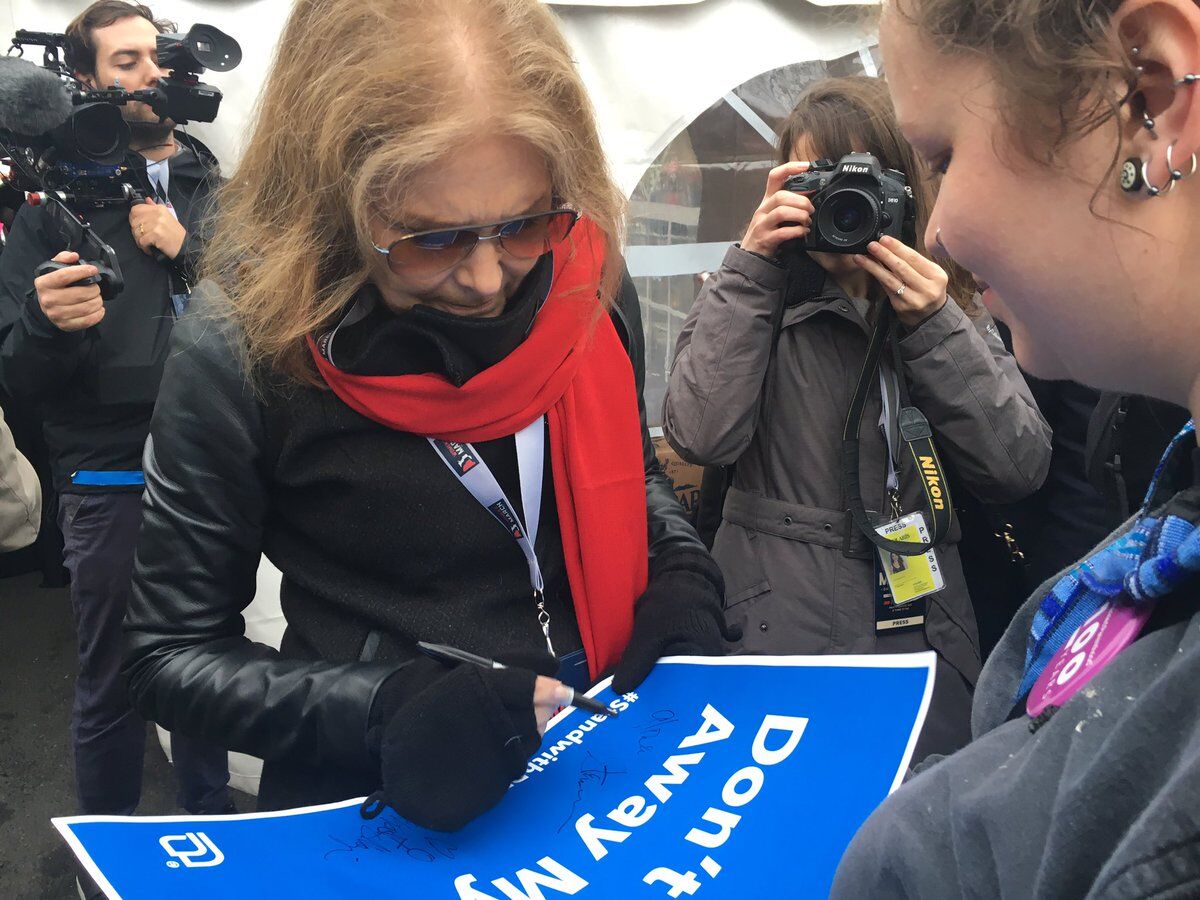 Gloria Steinem autographs a sign for a Women's March participant.