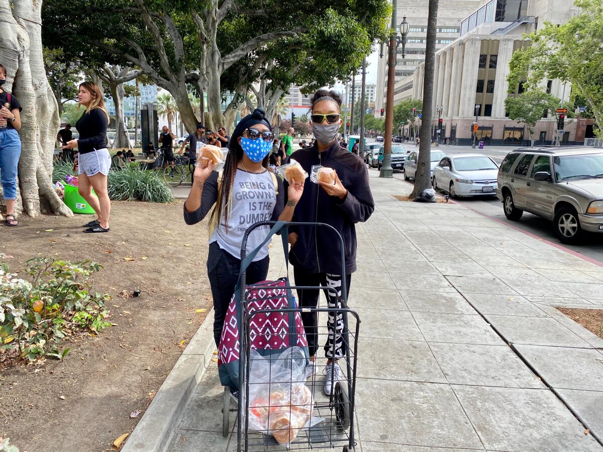 Brittney Holley and her cousin, Morris, pass out sandwiches at a downtown L.A. protest.