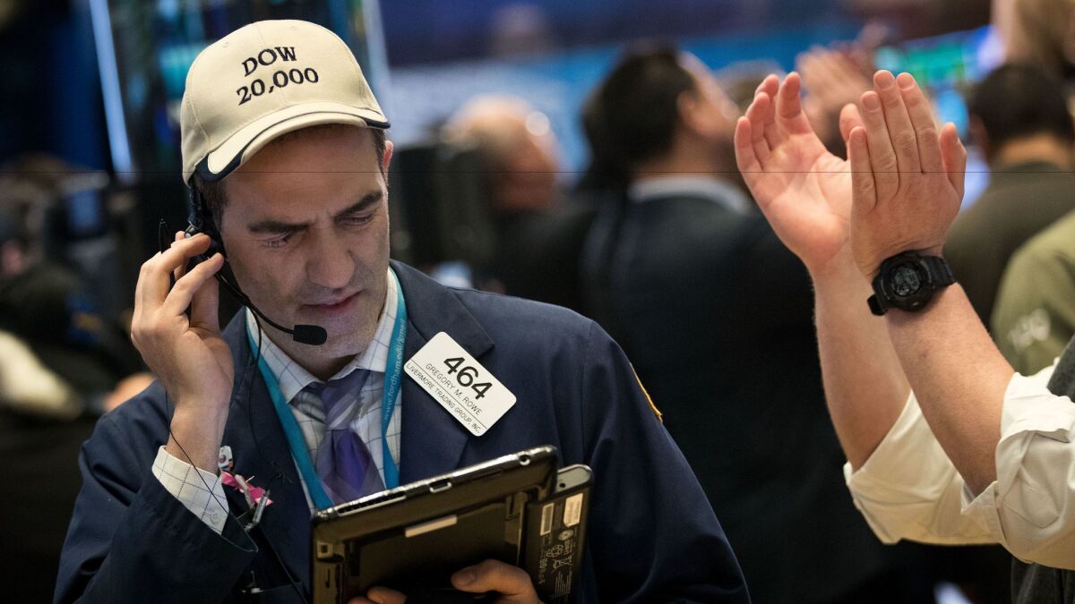 A trader wearing a "Dow 20,000" hat works on the floor of the New York Stock Exchange in December.