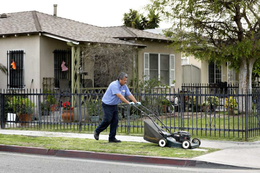 BOYLE HEIGHTS, CA-MARCH 19, 2018: Francisco Cruz mows the parkway in front of his home on 53rd St. in Maywood on March 19, 2018. His yard was cleaned up of lead contamination from the Exide plant a few years ago but the parkway was not. (Mel Melcon/Los Angeles Times)