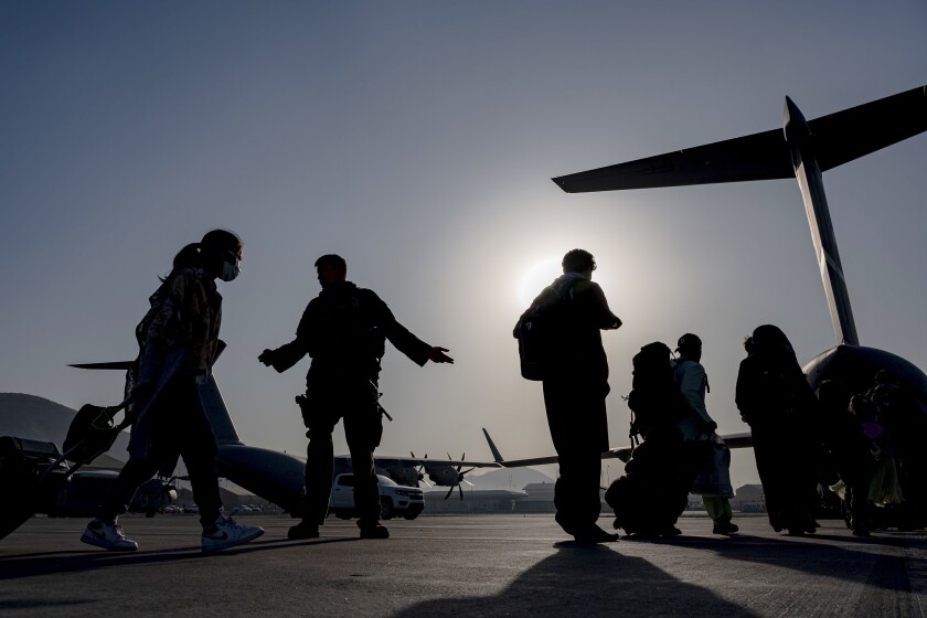 U.S. Air Force personnel guide evacuees at Kabul airport.