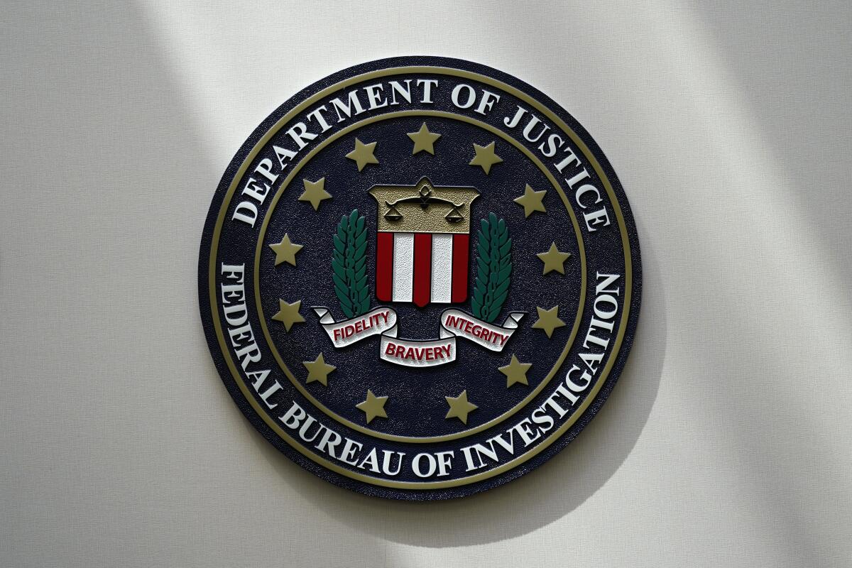 An FBI seal is seen on a wall.