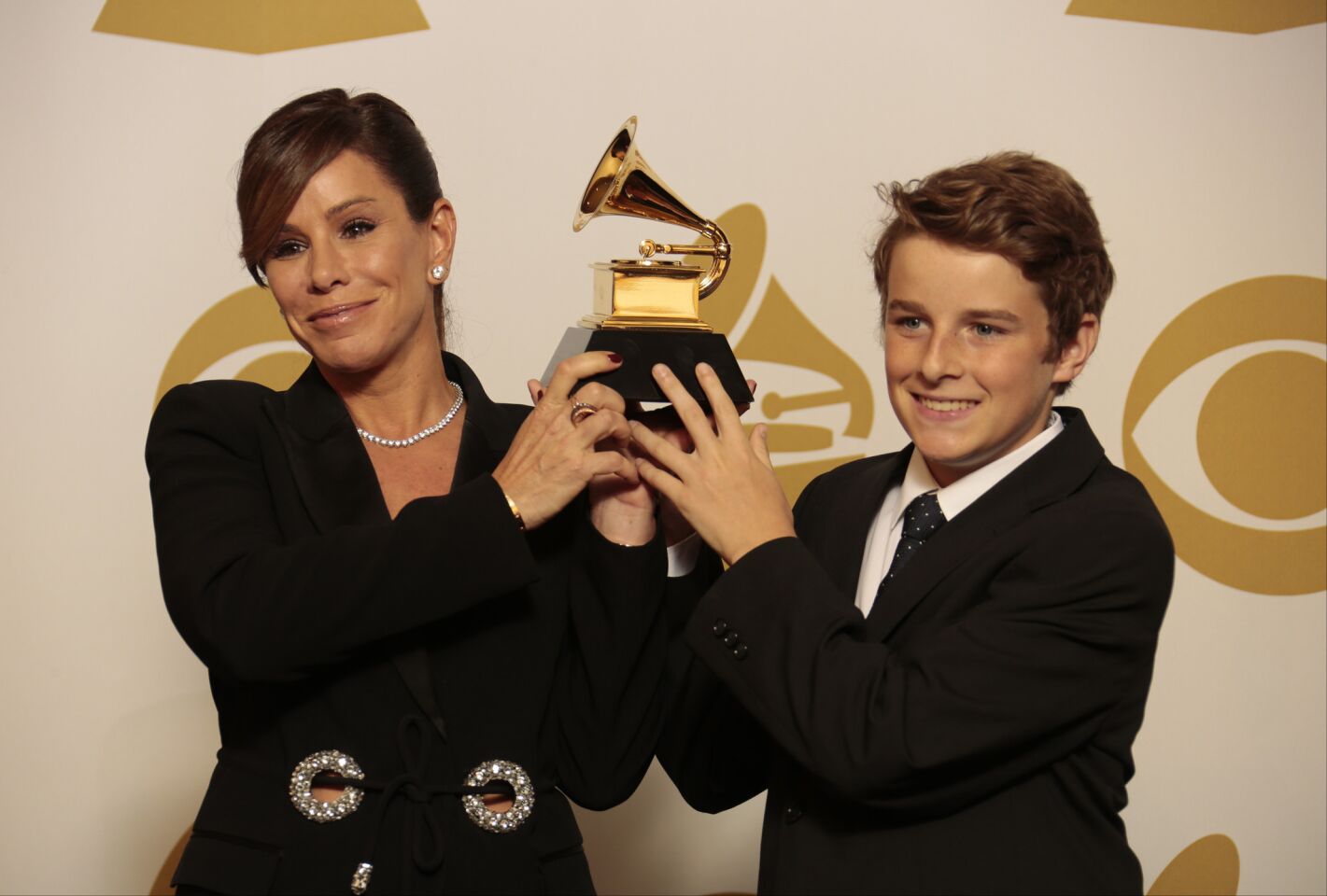 Melissa Rivers and her son hold up the Grammy awarded to her mother, Joan Rivers, for spoken word album for "Diary Of A Mad Diva."