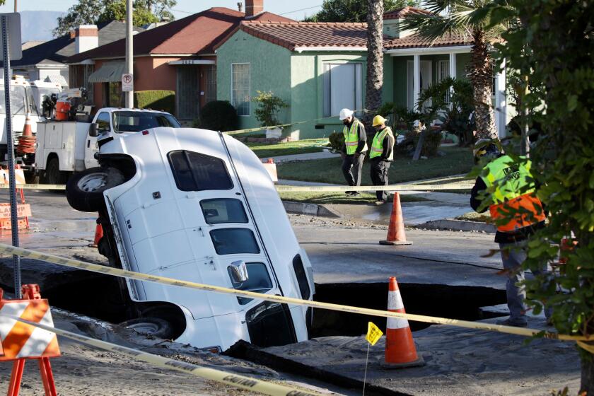 SOUTH LOS ANGELES, CA NOVEMBER 10, 2020 - A van fell into a sinkhole in South Los Angeles early Tuesday morning, November 10, 2020, which was created by a water main break. The sinkhole occurred in the 3600 block of South Buckingham Road, sending a van tilting into it. The van was parked at the time and no one was inside. (Irfan Khan / Los Angeles Times)