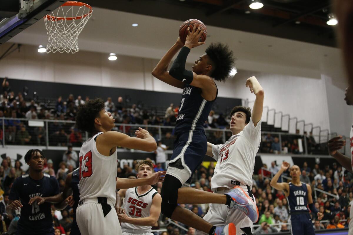 BJ Boston of Sierra Canyon attacks the basket as Kaleb Lowery tries to defend on Wednesday night at CSUN.