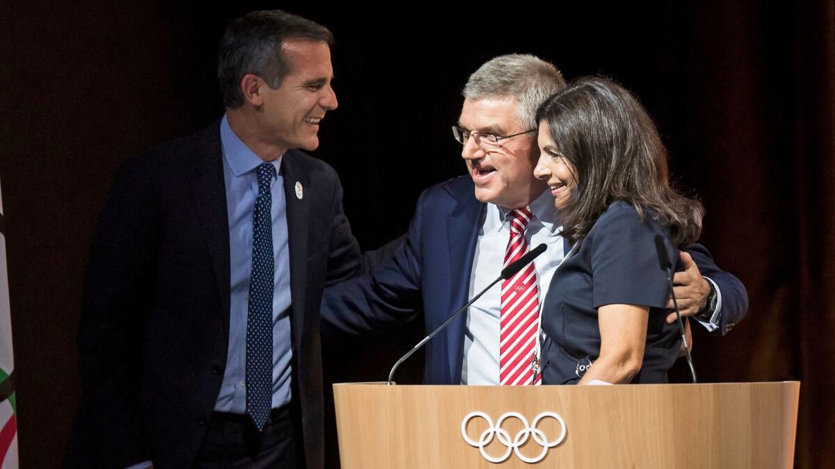 Los Angeles Mayor Eric Garcetti, left, International Olympic Committee President Thomas Bach and Paris Mayor Anne Hidalgo stand together July 11 in Lausanne, Switzerland.