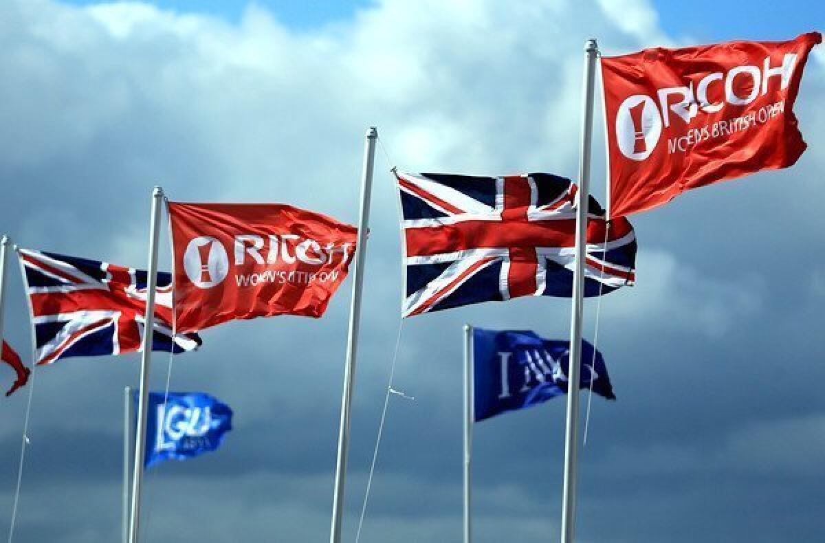 Flags strain against the wind Saturday during the third round of the Women's British Open in St. Andrews, Scotland.