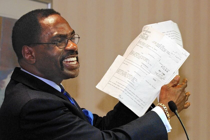 Former boxer Rubin "Hurricane" Carter holds up the writ of habeas corpus that freed him from prison, during a news conference held in Sacramento, Calif., in 2004. Carter, who spent almost 20 years in jail after twice being convicted of a triple murder he denied committing, has died at his home in Toronto at 76.