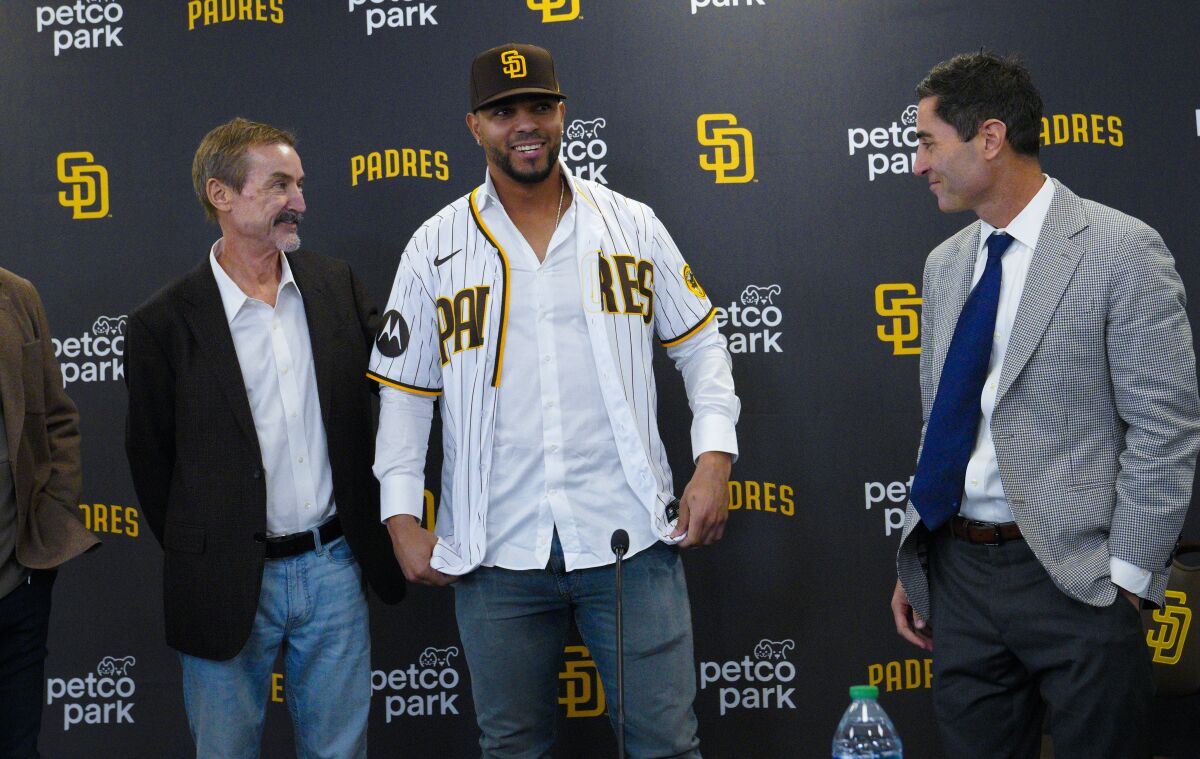 Xander Bogaerts tries on his Padres jersey at a December news conference