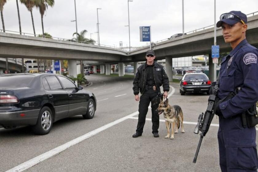 Los Angeles Airport officer Daniel Keene, left, police dog Axa and officer Fritz Corros stand at a checkpoint outside Los Angeles International Airport.