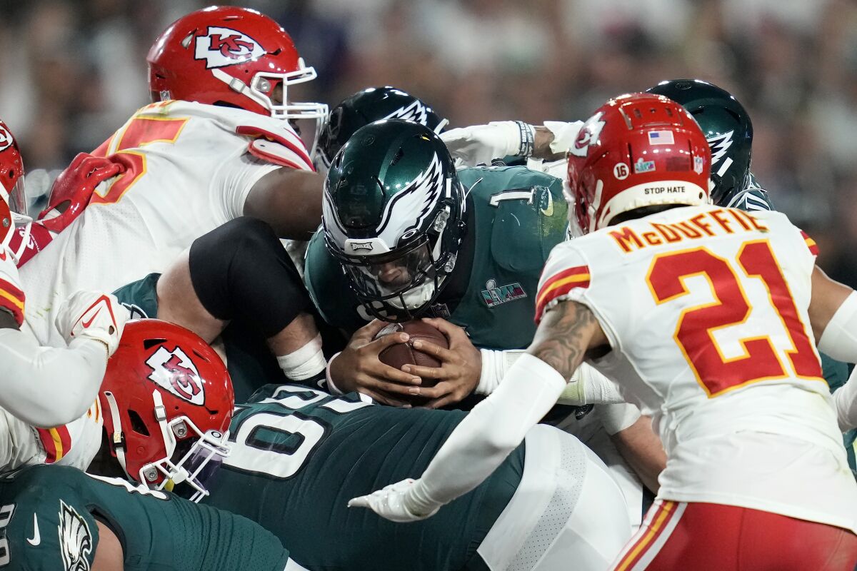 Philadelphia Eagles quarterback Jalen Hurts lunges for a first down while pushed by teammates against the Kansas City Chiefs.
