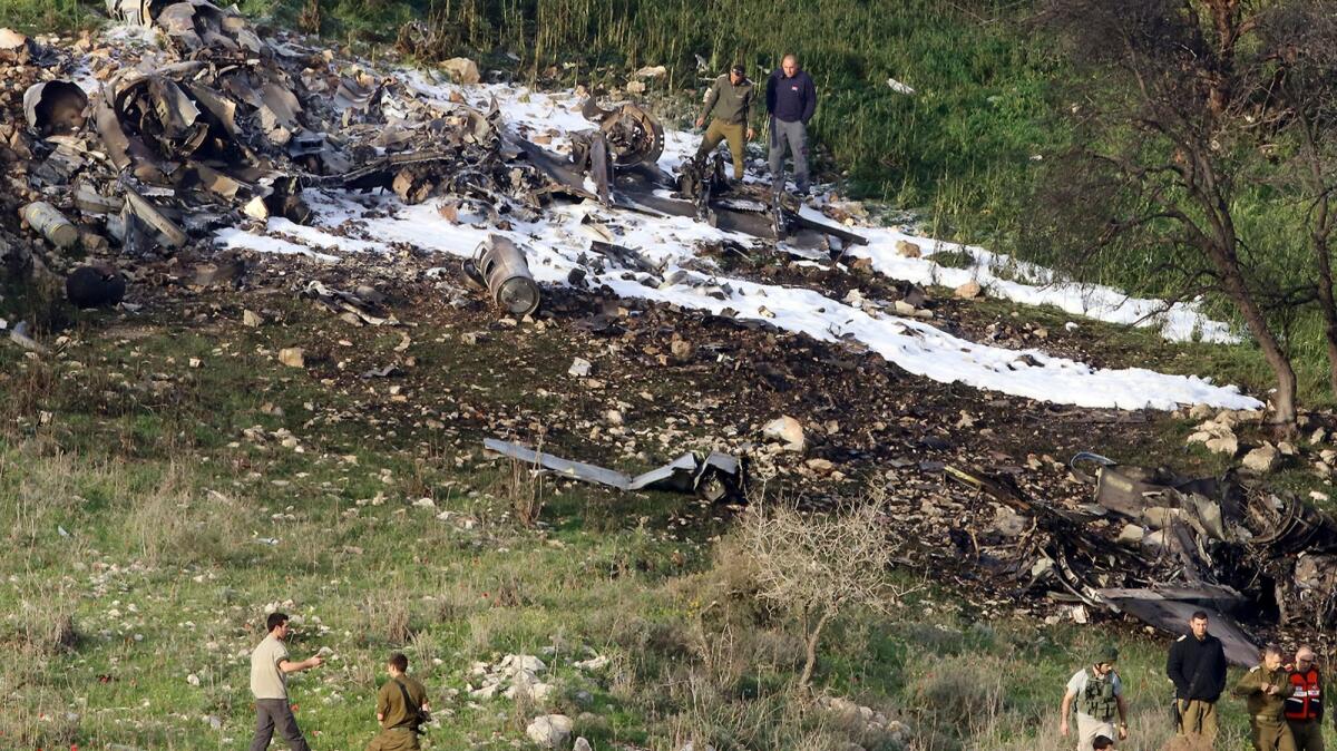Israeli security stands around the wreckage of an F-16 that was shot down Saturday in northern Israel, near the community of Hardouf.