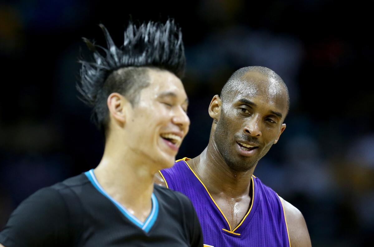 Lakers forward Kobe Bryant (24) talks to former teammate Jeremy Lin during a game against the Hornets.