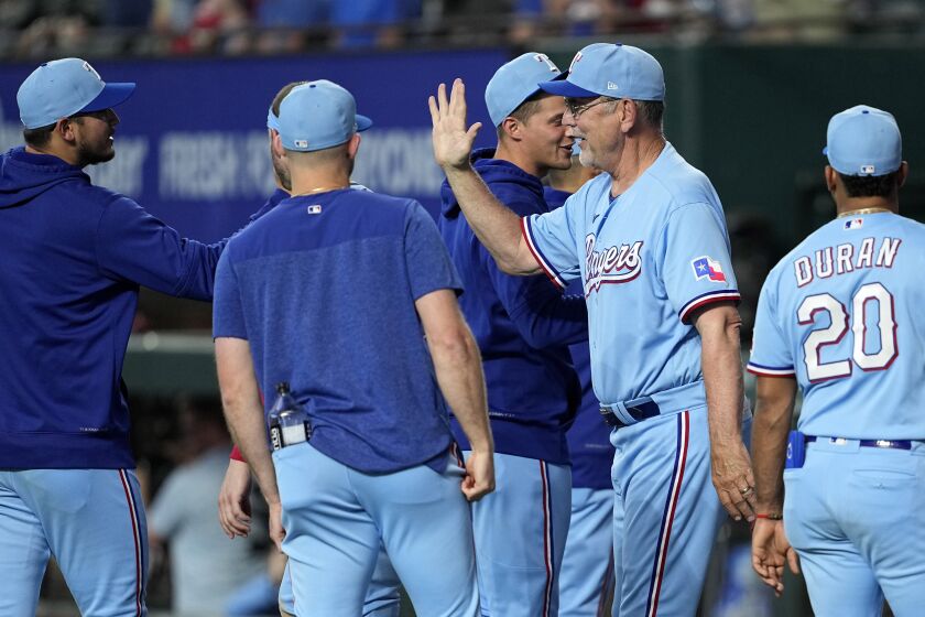 Texas Rangers manager Bruce Bochy, second from right, celebrates with Martin Perez, left, Ezequiel Duran (20) and others after their win in a baseball game against the Seattle Mariners, Sunday, June 4, 2023, in Arlington, Texas. (AP Photo/Tony Gutierrez)